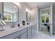 Well-lit bathroom featuring a double vanity and a glimpse into the bedroom at 130 Lapis Lake Pt, Fayetteville, GA 30215