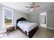 Relaxing bedroom with a scenic window view, ceiling fan, and stylish dark-stained wood furniture at 130 Lapis Lake Pt, Fayetteville, GA 30215