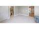 Large bedroom featuring neutral walls, carpet and entrances to a bathroom and hallway at 130 Lapis Lake Pt, Fayetteville, GA 30215