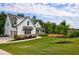 Beautiful white farmhouse with manicured lawn and stone accents at 130 Lapis Lake Pt, Fayetteville, GA 30215
