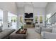 Inviting living room featuring a stone fireplace, gray armchairs, a view to the staircase, and hardwood floors at 130 Lapis Lake Pt, Fayetteville, GA 30215