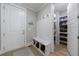 Mudroom area featuring a bench, coat hooks, and direct access to a pantry with storage shelves at 130 Lapis Lake Pt, Fayetteville, GA 30215