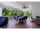 Covered outdoor patio with dining table, ceiling fan, grill, and views of the private wooded backyard at 130 Lapis Lake Pt, Fayetteville, GA 30215