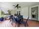 Well-lit patio featuring an outdoor dining set, a ceiling fan, and tranquil wooded views at 130 Lapis Lake Pt, Fayetteville, GA 30215