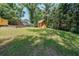 Large backyard with lush lawn and a small wooden shed, surrounded by mature trees at 213 Linda Dr, Tucker, GA 30084
