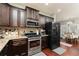 Well-equipped kitchen boasts stainless steel appliances, granite counters, and dark wood cabinetry at 2256 Long Bow Chase Nw, Kennesaw, GA 30144