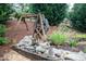 Water well in landscaped backyard features lush garden, stone pavers, and a tranquil outdoor water display at 2256 Long Bow Chase Nw, Kennesaw, GA 30144