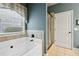 This bathroom has a large soaking tub beneath a window, with a glass-enclosed shower just to the right at 3491 Amerigo Dr, Buford, GA 30519