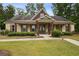 Charming brick home with a cozy front porch, complemented by lush greenery and a well-manicured lawn at 3491 Amerigo Dr, Buford, GA 30519