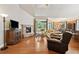 Open-concept living room with hardwood floors, a stone fireplace, and views into the dining and sun room at 3491 Amerigo Dr, Buford, GA 30519