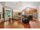 Open-concept living room with hardwood floors, a stone fireplace, and views into the dining and kitchen at 3491 Amerigo Dr, Buford, GA 30519
