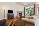 Cozy living room with hardwood floors, a stone fireplace, comfortable seating, and a view to the sun room at 3491 Amerigo Dr, Buford, GA 30519