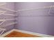 Spacious walk-in closet with light purple walls, wood floors, and multiple metal shelving units at 3491 Amerigo Dr, Buford, GA 30519