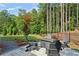 Patio has a fire pit surrounded by chairs perfect for gathering with lush landscaped backyard at 400 Southland Cir, Canton, GA 30115