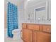 Bathroom with custom cabinet, tile floors, and a blue ruffle shower curtain at 602 Davenport Pl, Canton, GA 30115