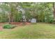 Expansive backyard with mature trees, lawn, and a cute shed, perfect for outdoor activities at 1980 Mcconnell Rd, Grayson, GA 30017