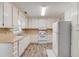 Traditional kitchen features white cabinets, appliances, neutral countertops, and modern flooring at 1980 Mcconnell Rd, Grayson, GA 30017