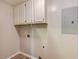 Bright laundry room with cabinetry, electrical panel, and utility connections at 1980 Mcconnell Rd, Grayson, GA 30017