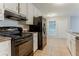 Galley kitchen with black appliances, tile floors, and white cabinets at 2341 Alden, Jonesboro, GA 30236