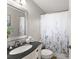 Well-lit bathroom showcasing a black granite countertop, decorative framed mirror, and floral-themed shower curtain at 4076 Shady Nw Cir, Lilburn, GA 30047