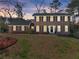 Inviting two-story brick home at twilight, showcasing its classic architecture and warm ambiance at 4076 Shady Nw Cir, Lilburn, GA 30047