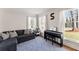 Bright living room with large windows, hardwood floors, a comfortable couch, and a piano at 4076 Shady Nw Cir, Lilburn, GA 30047