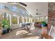 Charming sunroom featuring a vaulted ceiling, wall to wall windows, hardwood floors, and a brick wall at 4076 Shady Nw Cir, Lilburn, GA 30047