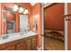 Charming bathroom with a wood vanity, decorative mirror, and a glimpse of a dinosaur-themed room at 4343 Sprucebough Dr, Marietta, GA 30062