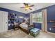 This cozy bedroom features a wood bedframe, ceiling fan, hats displayed, and natural light from the window at 4343 Sprucebough Dr, Marietta, GA 30062