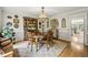 Formal dining room showcasing wood floors, decorative dishware, and natural light from the doorway to the kitchen at 4343 Sprucebough Dr, Marietta, GA 30062