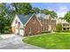 Brick exterior home with attached garages and spacious front yard with mature landscaping at 4343 Sprucebough Dr, Marietta, GA 30062