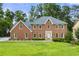 Beautiful two-story brick home with a well-manicured lawn and mature trees at 4343 Sprucebough Dr, Marietta, GA 30062