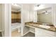 This bathroom has a vanity with a granite countertop, a large mirror, and a tiled shower at 8455 Cedar Creek Rdg, Riverdale, GA 30274