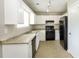 Efficient kitchen featuring white cabinets, stainless steel sink, and black appliances at 8455 Cedar Creek Rdg, Riverdale, GA 30274