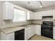 Functional kitchen featuring white cabinets, updated appliances, and ample counter space at 8455 Cedar Creek Rdg, Riverdale, GA 30274