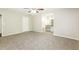 An empty main bedroom boasts an adjacent bathroom with vanity, gray carpet, and a ceiling fan at 8455 Cedar Creek Rdg, Riverdale, GA 30274