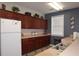 Kitchen area with stainless steel sink, dark wood cabinets and a white refrigerator at 179 Camry Ln, Grayson, GA 30017