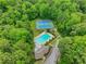 Aerial view featuring a community pool and tennis courts surrounded by lush green trees, creating a serene recreational space at 2535 Winthrope Way, Lawrenceville, GA 30044