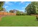 Expansive backyard featuring lush green lawn, mature trees, and privacy fence at 2535 Winthrope Way, Lawrenceville, GA 30044