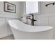 Elegant freestanding bathtub with a stylish faucet and wainscoting at 2535 Winthrope Way, Lawrenceville, GA 30044