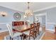Formal dining room featuring a wooden table with decorative chairs, hardwood floors, and elegant decor at 2535 Winthrope Way, Lawrenceville, GA 30044