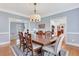 Elegant dining room with a large table, stylish chairs, crown molding, and views into the living spaces at 2535 Winthrope Way, Lawrenceville, GA 30044