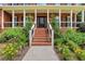 Inviting front entrance with brick steps, covered porch, and professionally landscaped garden beds at 2535 Winthrope Way, Lawrenceville, GA 30044