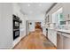 Bright kitchen featuring white cabinets, stainless steel appliances, and hardwood floors at 2535 Winthrope Way, Lawrenceville, GA 30044