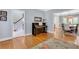 Open-concept living room with hardwood floors, a piano, and views into the dining area and staircase at 2535 Winthrope Way, Lawrenceville, GA 30044
