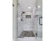 Modern shower with glass enclosure, marble tile, and a stone pebble floor at 2535 Winthrope Way, Lawrenceville, GA 30044