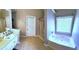Bright bathroom features a soaking tub, shower, and large vanity with plenty of counter space at 40 Pebble Brooke Ct, Covington, GA 30016