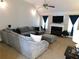 Cozy living room with a large sectional sofa, fireplace, and ceiling fan at 40 Pebble Brooke Ct, Covington, GA 30016