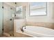 Spa-like bathroom features a soaking tub, a tiled glass enclosed shower, and natural light at 4155 Brookview Dr, Cumming, GA 30040