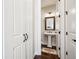 Elegant powder room featuring a pedestal sink, decorative mirror, and dark hardwood floors at 4155 Brookview Dr, Cumming, GA 30040